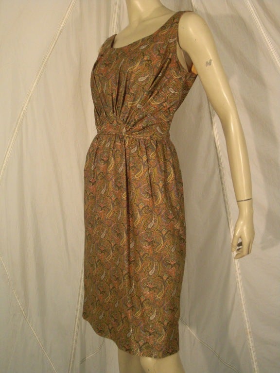 1960s paisley lurex cocktail dress:  Wiggle style with gathering at center waistline.  Zip back and lightly gathered skirt. Sold with matching fabric jeweled 