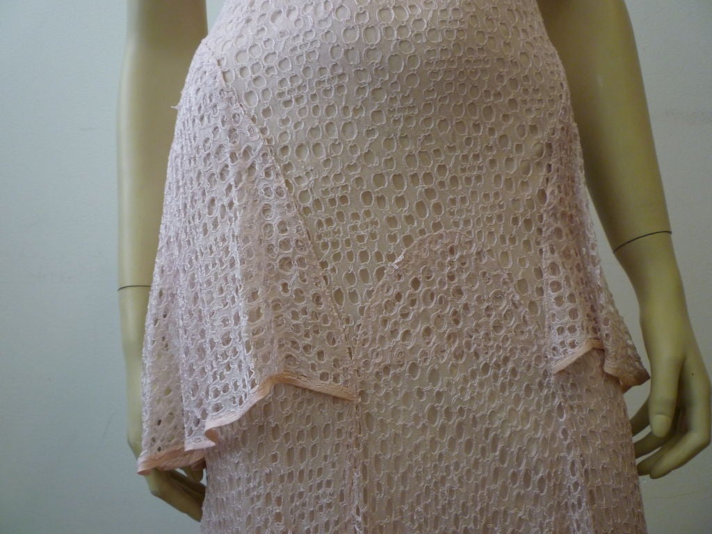 This 1930s Pink Eyelet Tulle Lace Gown is beautiful and demure in a soft shade of pink that is flattering to most and features design elements like a peplum and an overlayer on the back of the bodice.  Quite beautiful!