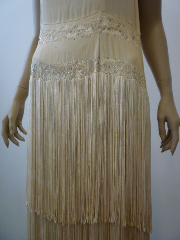 A gorgeous, statuesque 1920s ivory silk wedding gown with long, triple tiered silk fringe with added rhinestone embellishment and added swag.