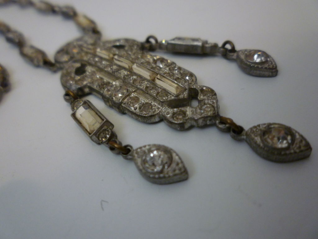 1930s elegant cast white metal pendant necklace with drops in baguette and round shaped rhinestones. Pendant w/ drops measures 2 1/2