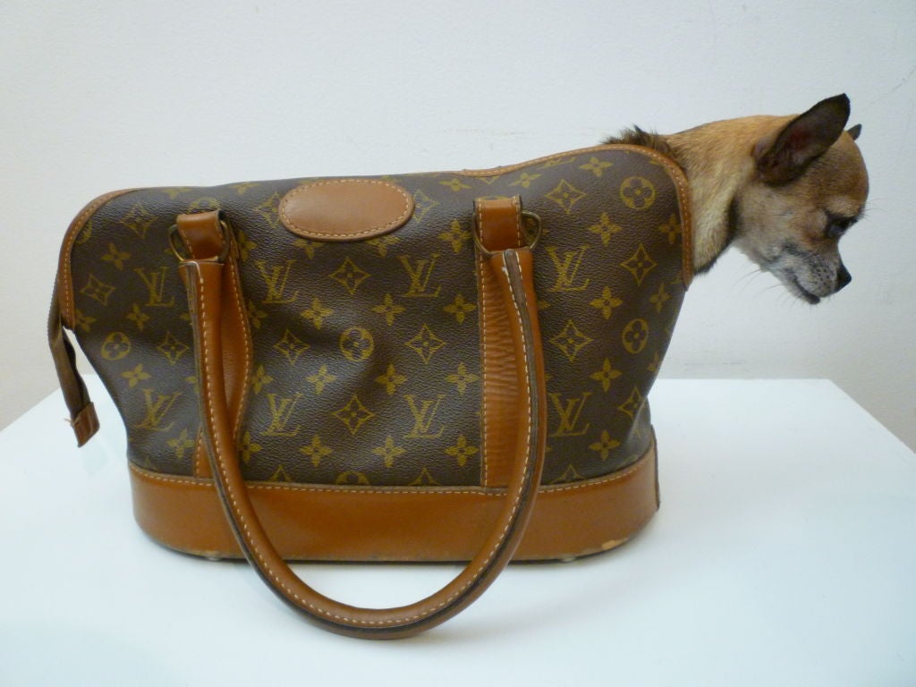 Louis Vuitton monogram canvas dog carrier from the early 80s.  Pre-dyed leather. Lined in vinyl. Metal feet, zippered closure.