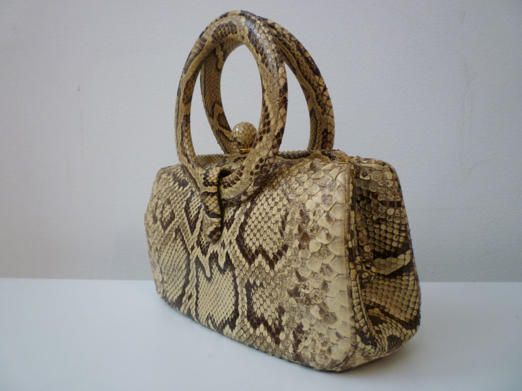This is a woderfully chic and compact snakeskin handbag with covered ring handles and covered ball clasp!  <br />
<br />
Measurement are <br />
10