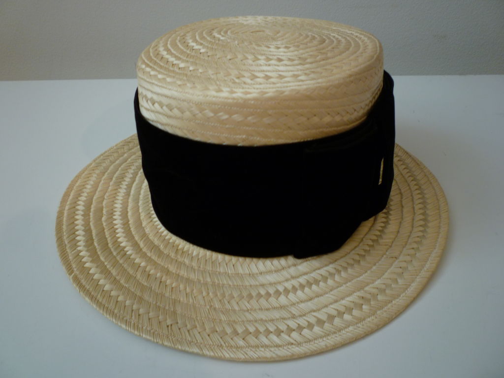 Wonderful Chanel boater of woven straw with asymmetric brim, tall crown and wide silk velvet band.
