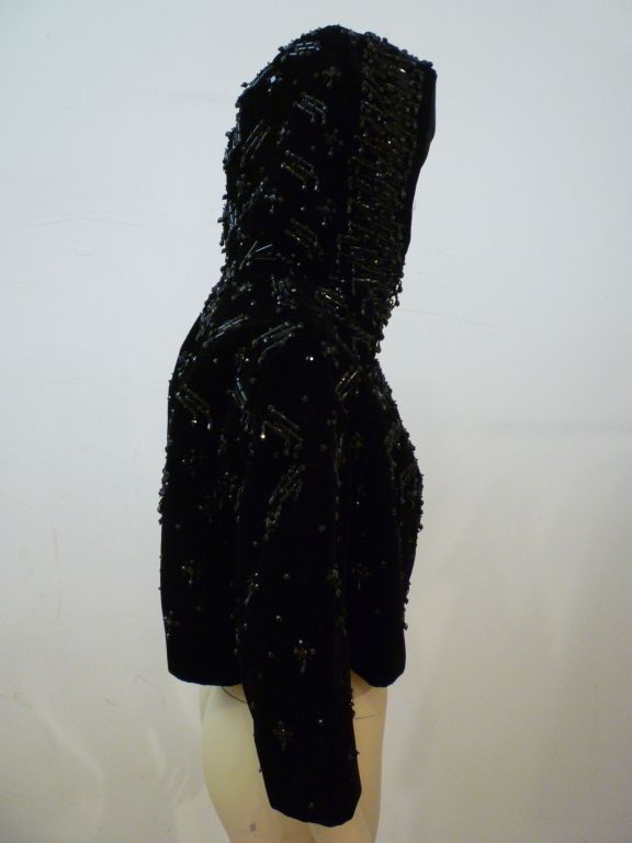This is a spectacular avant garde 1950s I. Magnin beaded velvet cropped evening jacket with a hood!  Made in France.  The beading design in quite modern as is the Japanese inspired cut.  3/4 length sleeves!