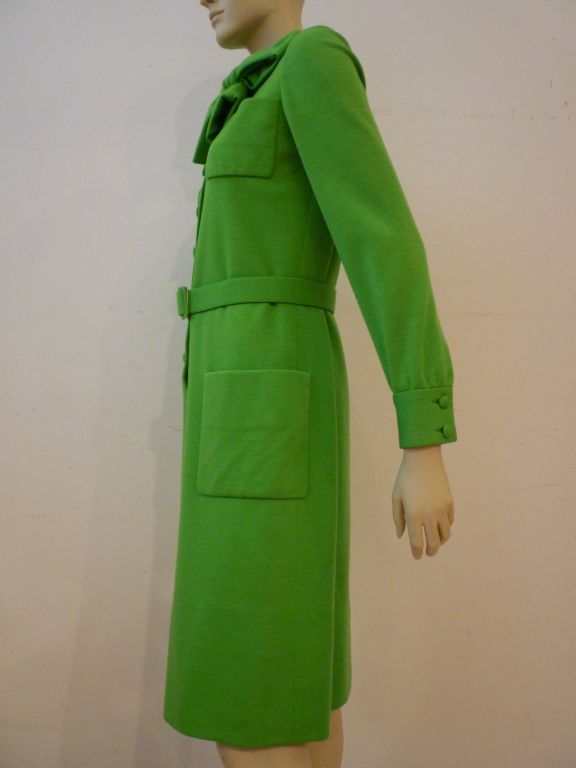 A wonderful, chic Norman Norell for Bonwit Teller apple green wool double knit day dress with covered buttons, 4 patch pockets, matching belt, button cuffs and foulard tie neck. Silk lined. In excellent condition