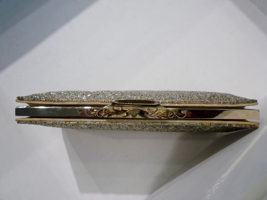 A gorgeous, sophisticated 1950s clutch, hand-beaded (guaranteed by a label inside) with an etched silver frame.  Interior lined in cream color moire faille fabric.  Medium in size, it is large enough for a functional evening bag!  Measures 8.5 x