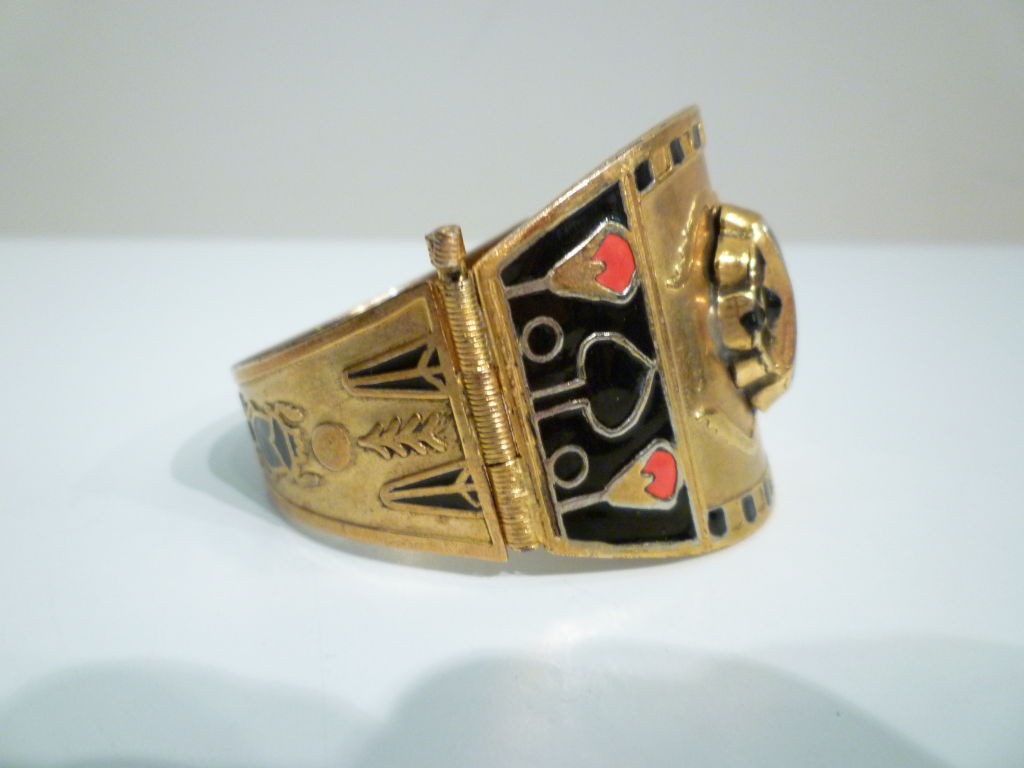 A fabulous Egyptian themed brass and enamel bracelet with scarab and lotus imagery.  Black and red enamel on brass.  Opens with a pin closure.  7 3/8