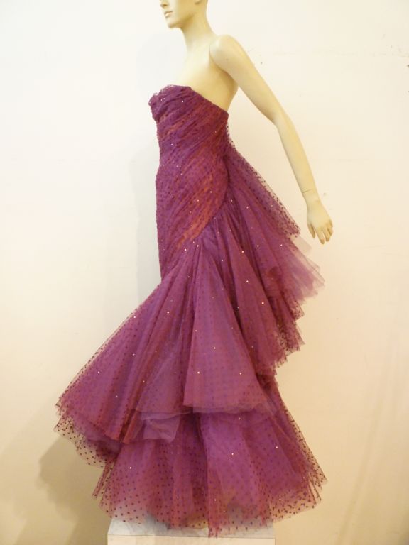 A wonderful Wilma couture gown of purple silk point d'esprit tulle embellished with rhinestones.  Optional rhinestone straps or strapless constructed and ruched tulle column dress with a dramatic tulle ruffle hem which sweeps up the back.  Gorgeous!