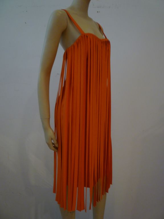 A exciting 1960s car wash fringe dress in bright orange crepe!  A fitted sheath underneath and carwash fringe around the front and back--a party waiting to happen!