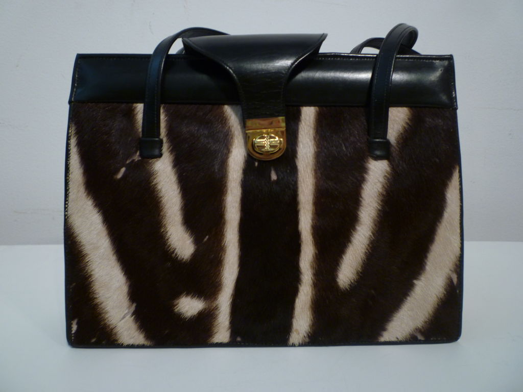 A very modern looking 60s leather and zebra hide handbag with gold tone hardware, with double straps, snaplock closure and leather fold-over flap.<br />
<br />
Measures:<br />
11' x 8.5