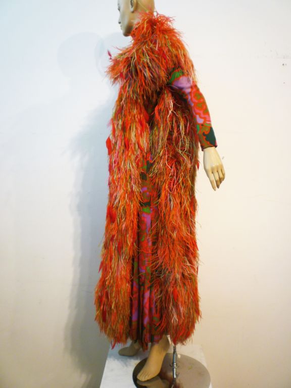 A exuberant example of 60s high fashion.  A George Halley psychedelic print silk dress with silk chiffon overlay and extravagant multi-color ostrich and turkey feather trim!  A party waiting to happen!