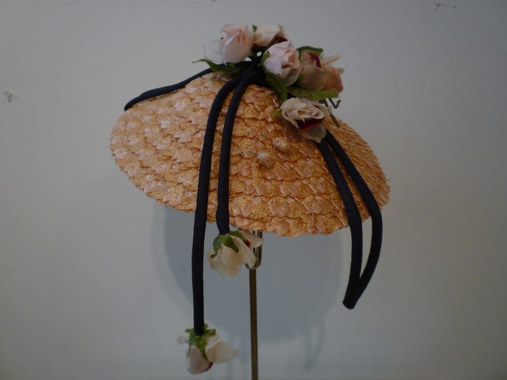 Un autre fabuleux chapeau de paille des années 50, de forme conique, de couleur pêche, avec des fleurs en soie et une garniture en velours noir.