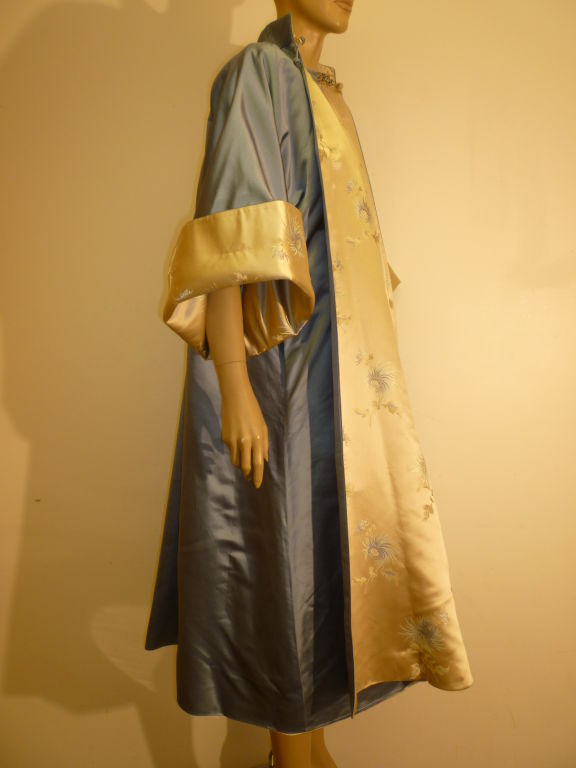 A gorgeous 2-piece 50s ensemble custom made in Hong Kong of silk satin and brocade in tan and slate blue.  Dress is in a classic 50s style with fitted waist, flair and pleated skirt, low V back and gorgeous reversible swing coat.  Size 4-6.  Coat