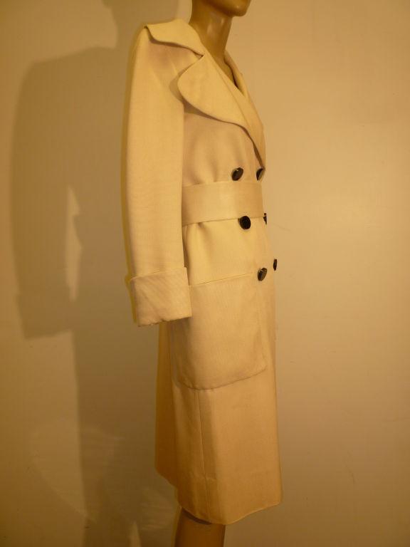 Norman Norell 1960s cream silk/linen gazar belted trench with patch pockets and double breasted black buttons. Gorgeous deeply notched rounded peak lapels!