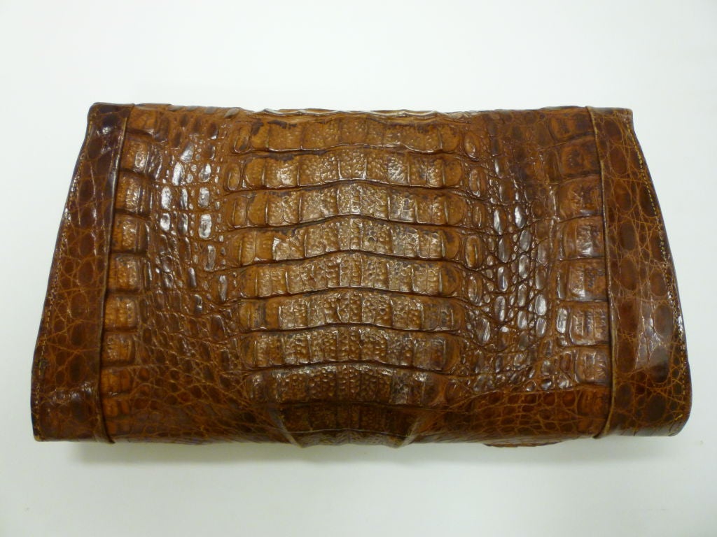 An amazingly beautiful and heavily scaled brown genuine alligator clutch from the 40s.  Made in Cuba and in wonderful condition, with a clean brown leather lining and a slide closure.<br />
<br />
Measures <br />
13