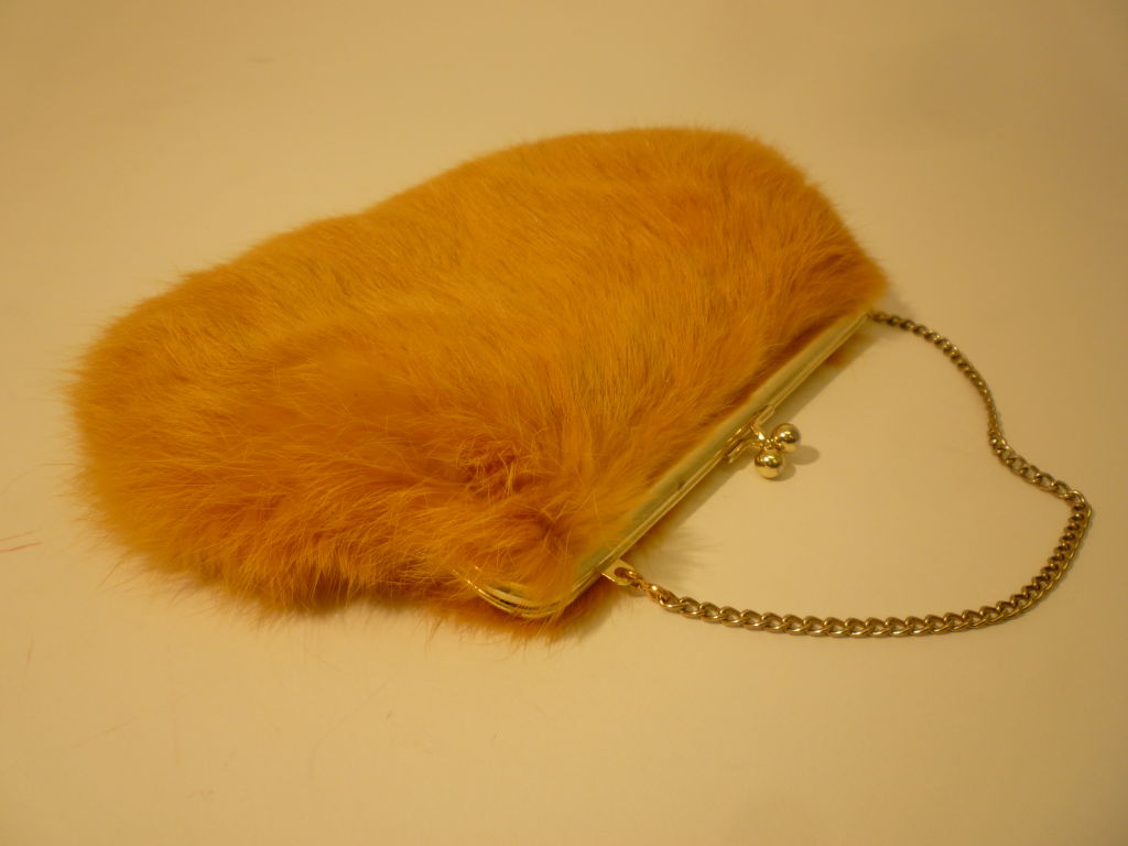 A fun 60s Ingber handbag in dyed golden yellow lapin fur with a convertible chain strap that can be hidden to make a clutch.  Measures 10