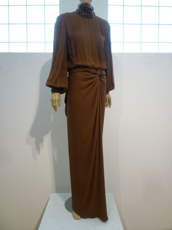 A fantastic brown silk chiffon evening gown from James Galanos with draped column skirt and pleated bodice and balloon sleeves.  Neckline and cuffs are embellished with gray, silver and topaz color beading.