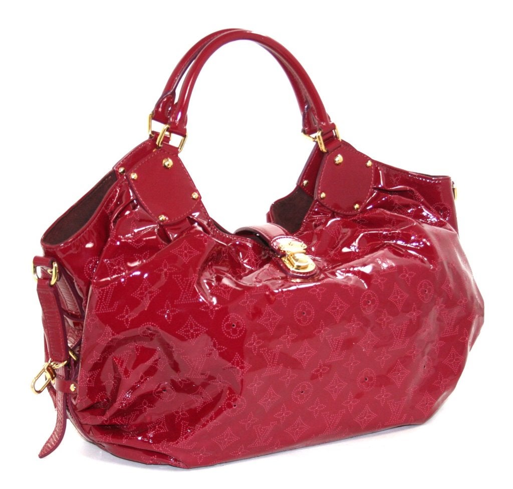 This authentic Louis Vuitton Cerise Monogram Patent Leather Surya XL Mahina is in mint condition, perhaps carried two or three times.  The limited edition collectible is from the 2009 season. 
 
 Extra-large slouchy and sexy hobo in durable