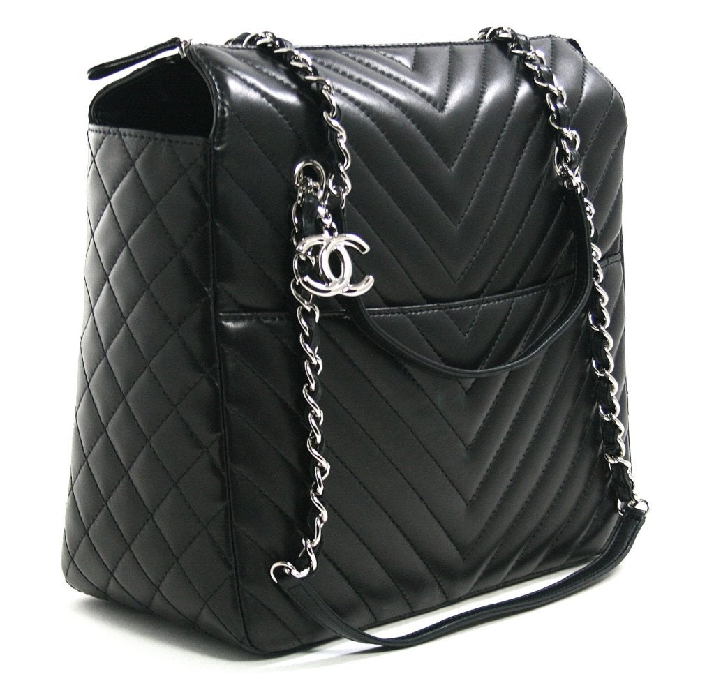 This authentic Chanel Black Lambskin Surpique Chevron Large Tote is in pristine unworn condition.  A timeless classic that is perfectly suited to both the country and the city; it is certain to become a wardrobe favorite.
 
Black lambskin tote is