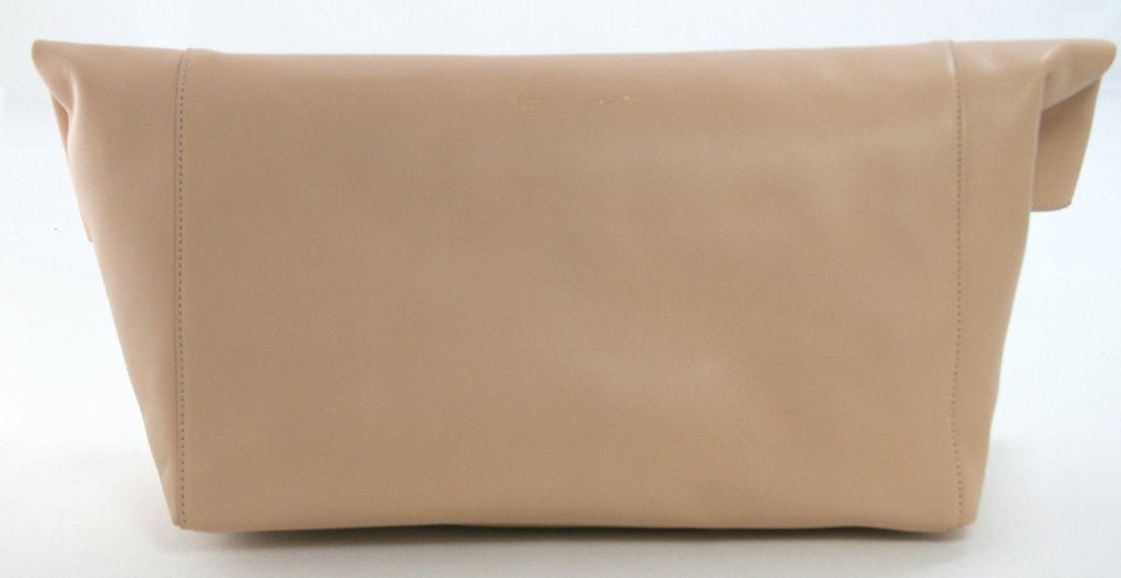 This authentic Celine Beige Leather Folded Clutch is in nearly pristine condition, carried only one time.  Simple tailored styling makes this roomy clutch a fantastic addition to any sophisticated wardrobe. 
 
Neutral beige leather clutch is
