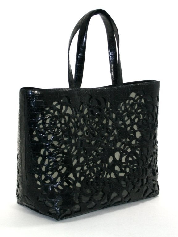 This authentic Nancy Gonzalez Black Floral Laser Cut Crocodile Tote is a brand new store display, never before carried.  The perfect summer carryall transitions beautifully from the beach to the restaurant without skipping a beat. 
 
Smoky PVC tote