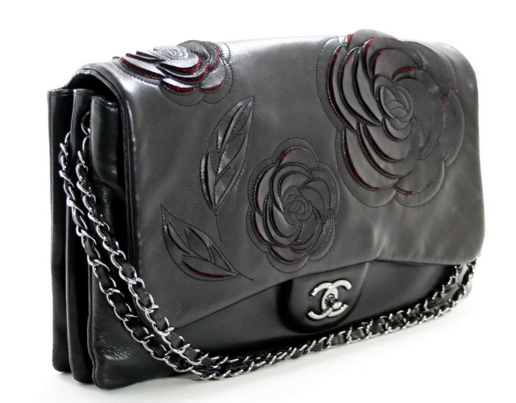 This authentic Chanel Black Lambskin Camellia Runway Flap Bag is in mint condition with no significant signs of prior ownership.  A special edition piece, it is totally sold out and no longer in production.
 
Luxuriously soft black lambskin is
