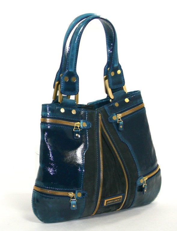This Authentic Jimmy Choo Dark Blue Patent Leather Mona Tote is in better than excellent condition with no significant signs of use.  The convertible style is especially rich in a stunning peacock blue with gold tone hardware.
 
Deep blue textured