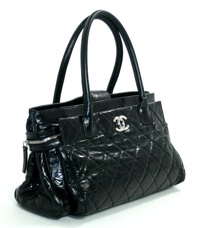 This Authentic Chanel Black Glazed Calfskin Portobello Tote is in beautiful condition with slight signs of wear.  There is subtle corner and handle wear; best described as a bit of rough texture beneath the handles.  Perfectly scaled for chic daily