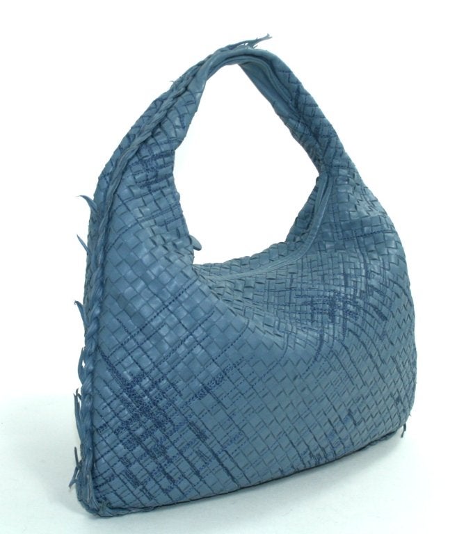 This Authentic Bottega Veneta Krim Blue Leather Fringed Veneta Bag is in better than excellent condition with only very subtle handle wear.  This unique limited edition version of the large Veneta has unfinished braiding around the edges and