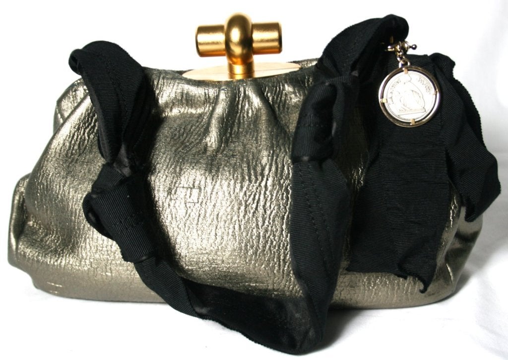 This authentic Lanvin Pewter Evening Bag is in excellent condition with minor signs of general prior ownership.
 
Metallic pewter leather has gold undertones and a uniquely textured surface.  Matte gold clasp acts as the focal point on top.  Black
