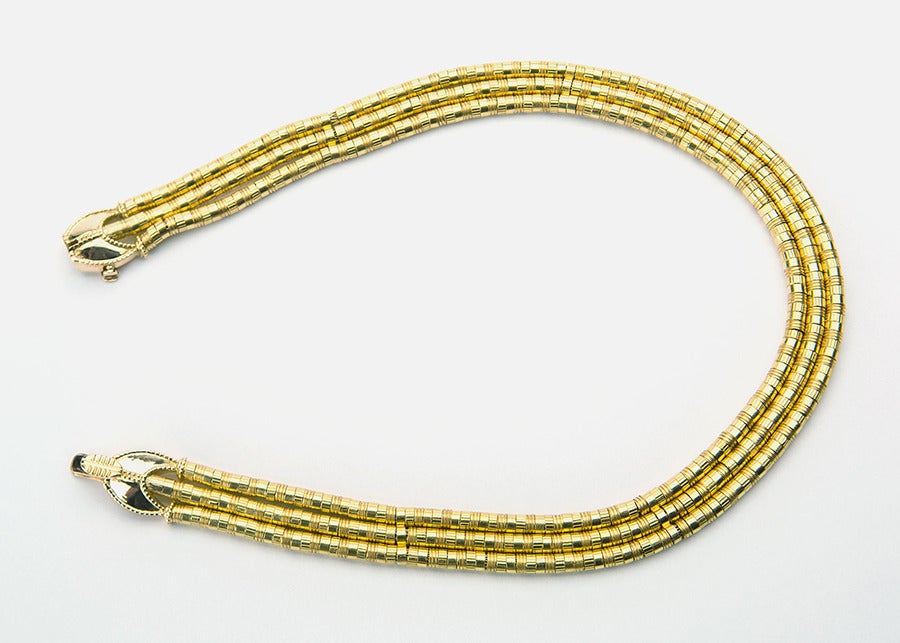 Lush strands of woven gold nest to create a simple and elegant collar necklace.