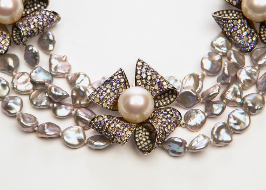Elegant classic bows cradle large South Sea pearls.  Finished with over 20 carats of diamonds and 12 carats of multicolored sapphires.  All tied together with lush baroque pearls.  Simply wow!