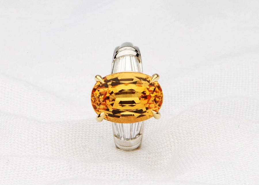 A 7ct and precious topaz dominates this classic ring, flanked by 10 tapered baguette diamonds.