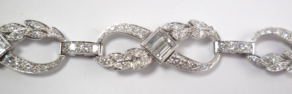 Set to the front in 950/- palladium with graduated brillant-cut and baguette-cut diamonds, designed as leaves, swags and squares with five links, case-lock. Estimated diamond weight: 6.5 ct.