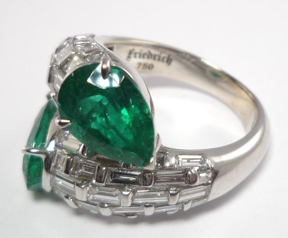 Double snake design, with two pear shaped natural Colombian emeralds and baguette-cut diamonds set in brick design.