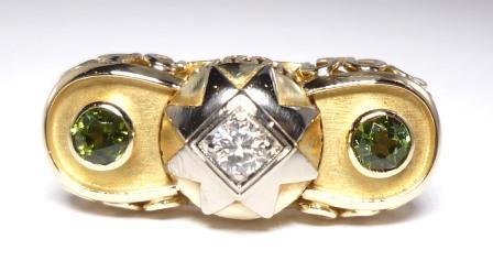 Typical of the mature Art Déco period, designed as a balcony holding 2 peridots in brillant-cut and 1 brillant-cut diamond within a star in 585/- white and yellow gold. 
Handcrafted.
Ring Size 8 (US), European 57