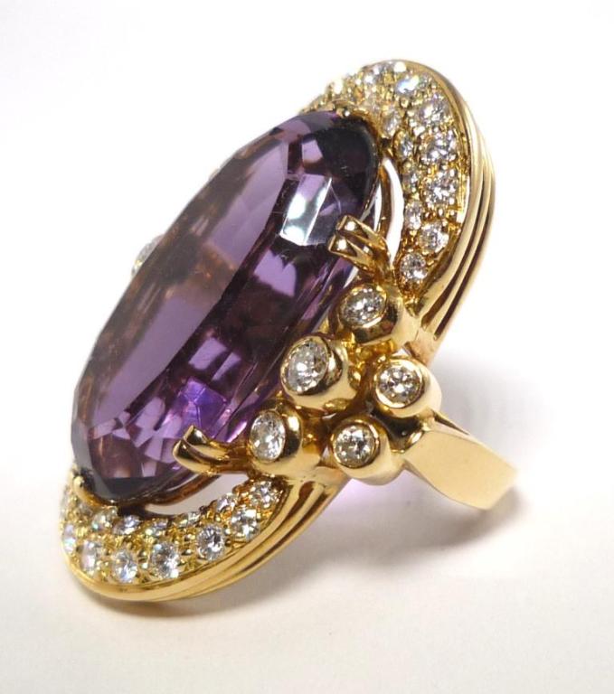Designed as a cluster of brillant-cut Diamonds surrounding an oval-cut Amethyst centre Stone.