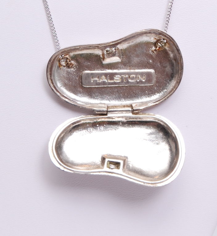 1970's Elsa Peretti for Halston, medium sized shiny silver bean locket necklace. Large interior, stamped Halston. Pendant style with a fine silver chain attached at each end on top.<br />
<br />
<br />
Halston<br />
Roy Halston Frowick, a studio
