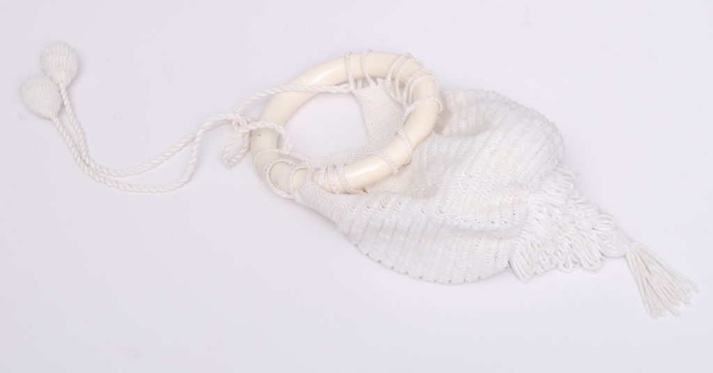 Silk crocheted pouch with matte white glass beading and tassel. Cleverly designed to be held on the wrist by the resin bangle holding the loops of the purse that can be moved around the bracelet to open the sac.<br />
The purse has been kept in