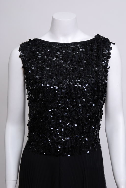 Black cocktail dress embelished with black beads and paillettes that sway and give a beautiful movement to the dress. The outer layer of the skirt is knife pleated and fully lined.
