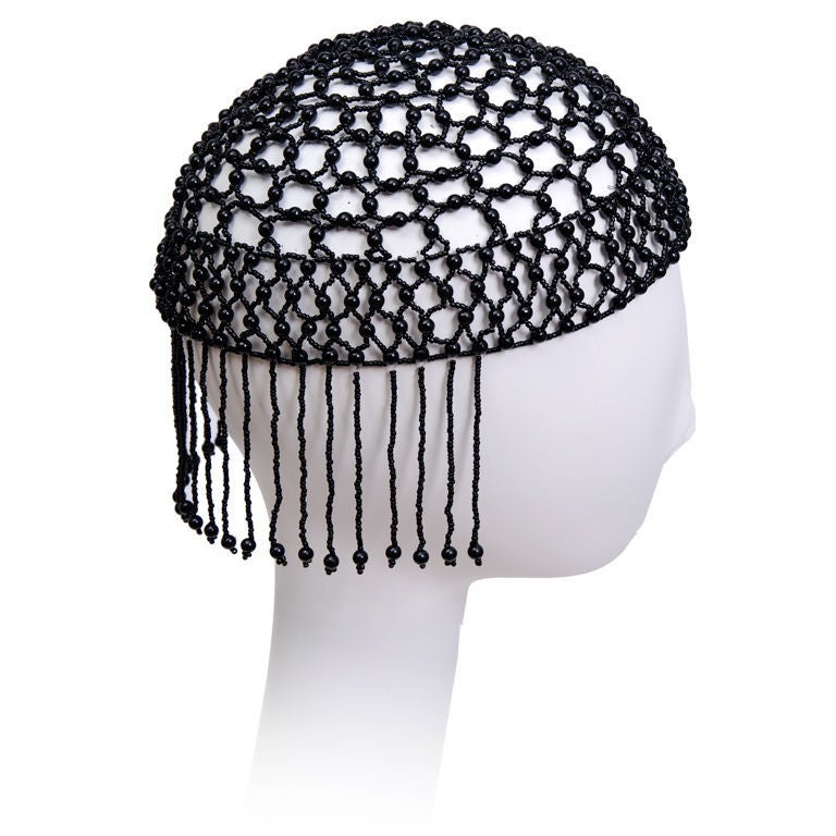 Black glass and plastic mesh cap with fringe detail at the back. Elasticized.
