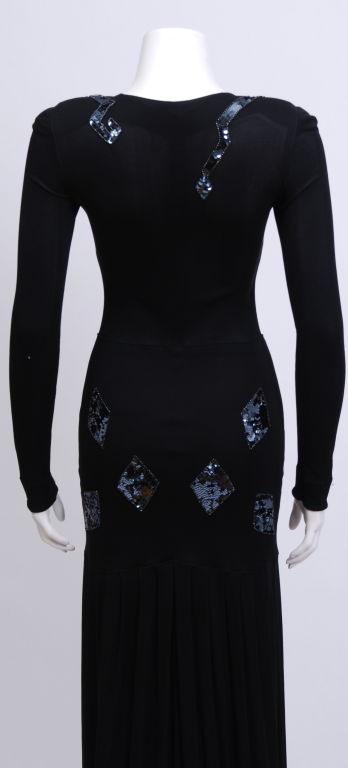Jean Muir black silk jersey long sleeve dress with snake sequin detailing around the neckline and diamond motif decor around the hips. Drop waist with kick pleats.