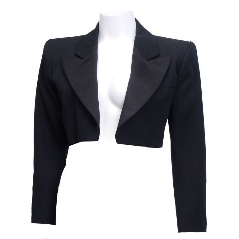 YSL cropped wool tuxedo smoking jacket with polished resin buttons. Silk satin lapel. Kept in pristine condition.<br />
<br />
Y.S.L.  1936 -2008<br />
Yves Saint Laurent was the most prolific designer of his time. Starting his career at the