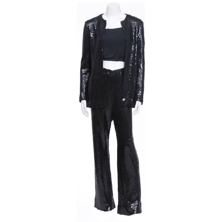 Three piece black sequin pant suit. This glamorous suit also has the luxury of comfort. All three pieces are made of silk jersey. The jacket and pants are adorned with a multitude of glossy black sequins. The pants have an elastic waistband as so