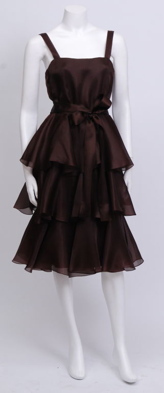 Beautiful, flowing tiers of brown silk organza, silk satin ribbon sash and straps. Falling just below the knee.

Oscar de la Renta (born Oscar Aristides Renta Fiallo) was born in Santo Domingo in Dominican Republic, to a Dominican mother and a