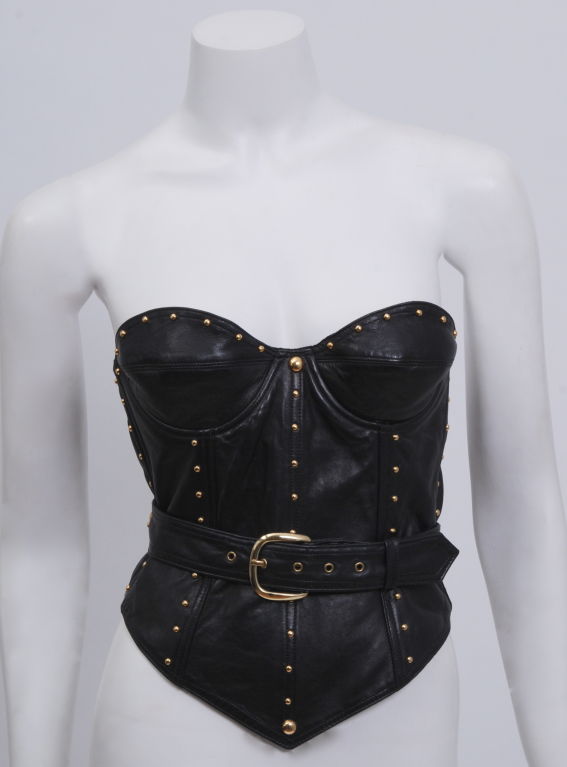 Isaac Mizrahi soft, shiny lambskin corset, studded with shiny gold domes down boning and edges, with wrap around belt. Shown in original collection with full skirt. Looks beautiful with leggings, skirts, jeans and over dresses.<br />
Kept in