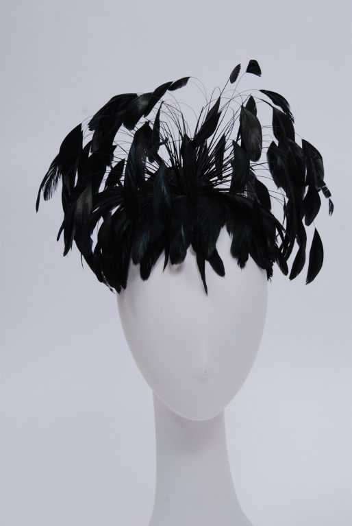 Black velvet hair band decorated with black opalescent, trimmed and shaped rooster feathers jetting out. The feathers sway and dance with movement when worn.