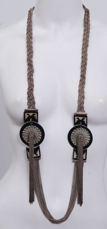 Very unique, extra long, intricately braided silver chains which are then braided together to form a rope. Light turquoise, buttercup yellow and black bakelite disks decorated with marcasite stones over delicate silver flowers and silver tassels.