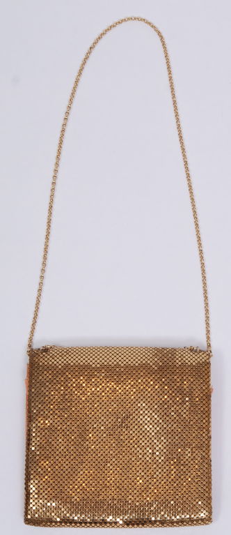 Whiting and Davis shiny gold mesh purse with fold over flap closure and shiny gold chain strap that can be worn long or doubled for a shorter look.
