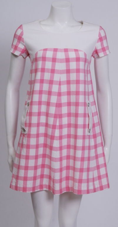 Woven cotton, pink gingham, a-line, sleeveless summer mini dress. Fully lined in white silk, back zipper, pockets with silver colored metal and white plastic button decoration.